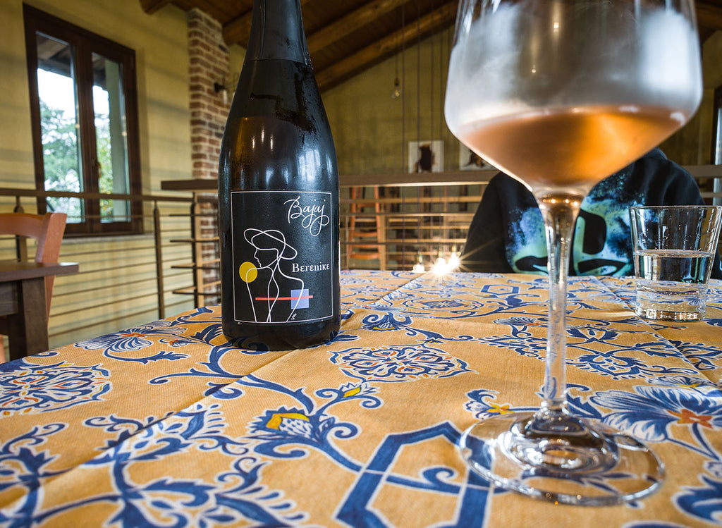 Bajaj Adriano Moretti Spumante Sekt Berenike aus Barbera Flasche auf Tisch mit eingeschenktem Glas