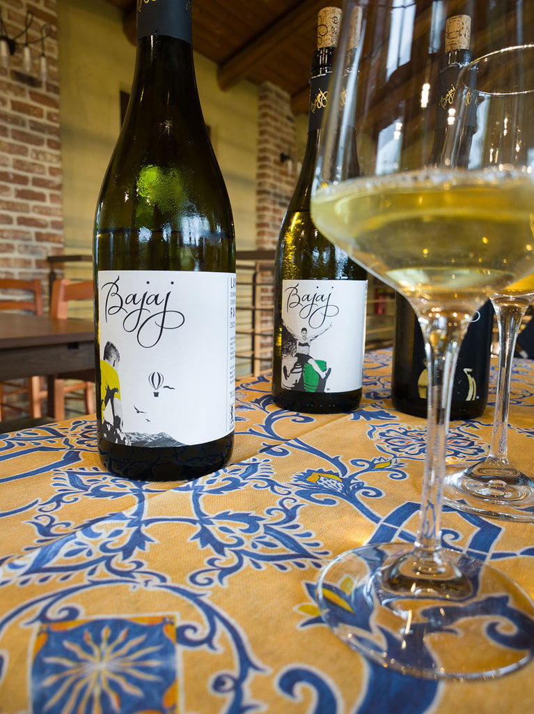 Langhe Favorita DOC von Bajaj Flaschen auf Tisch mit Glas Weißwein eingeschenkt