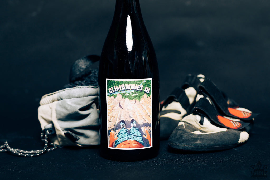 Climbwines III Free Solo Flasche mit Kletterszene neben Kletterschuhen und Chalkbeutel