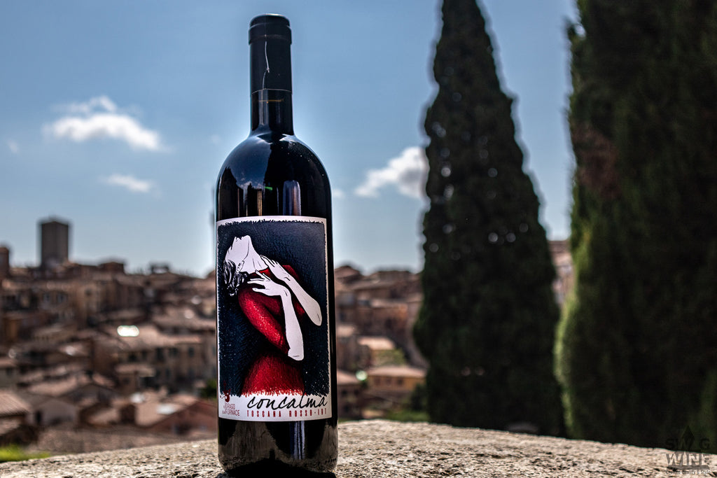 Concalma Toscana Rosso IGT Rotwein auf einem Stein vor Stadkulisse und Zpressen in der Toskana