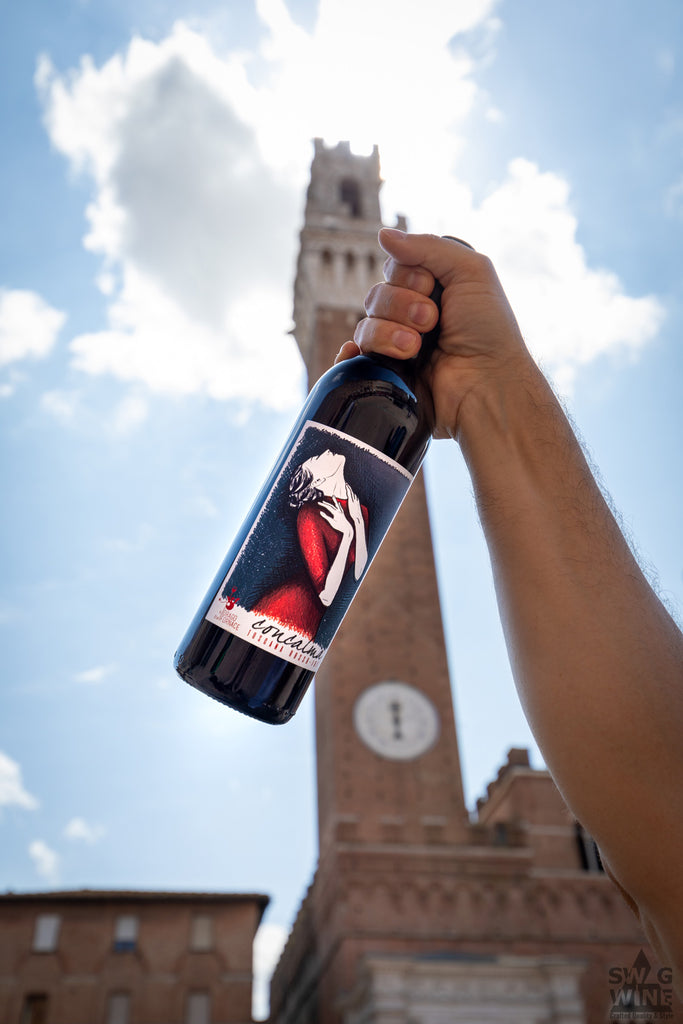 Concalma Rotwein Toskana Flasche in Hand vor einem Turm in Siena