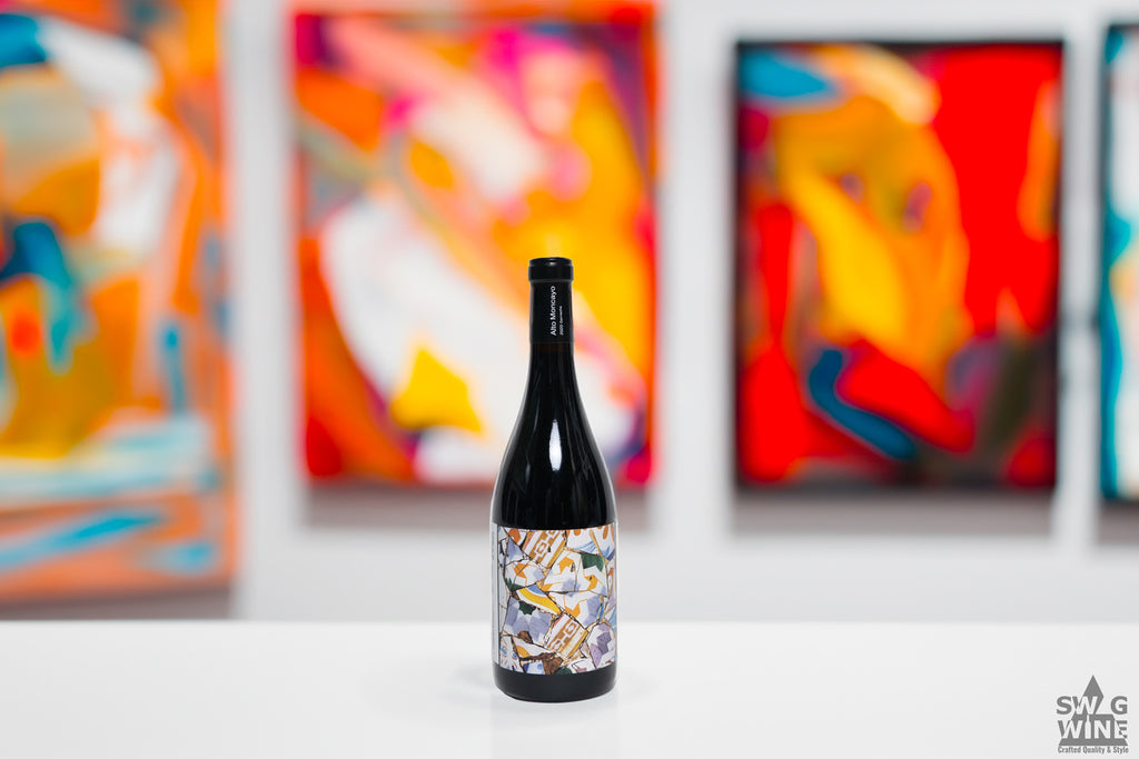 Garnacha Veraton von Alto Monayo aus Spanien - Weinflasche mit Künstleretikett vor Bilder einer Kunstgalerie.