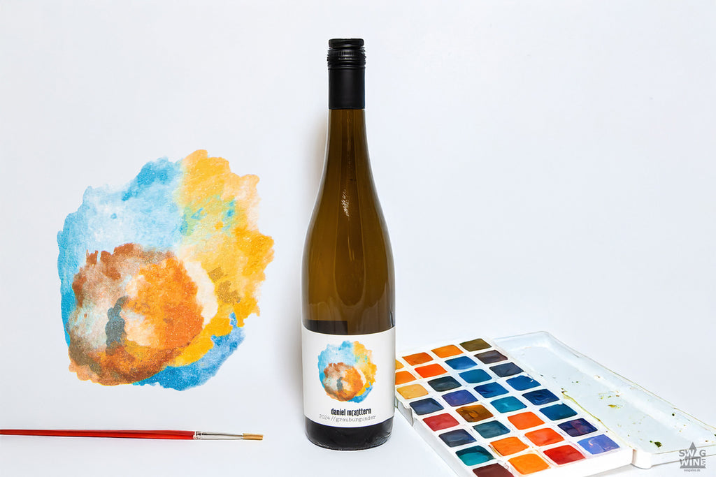 Grauburgunder von Daniel Mattern aus Rheinhessen - Flasche neben Farbkasten und Pinsel mit Farbklecks