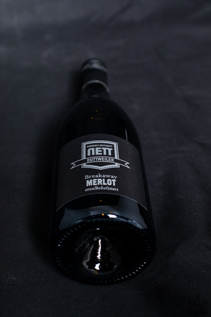Merlot Breakaway - alkoholfreier Rotwein von Bergdolt-Reif und Nett aus der Pfalz - elegante Flasche auf schwarzem Samt