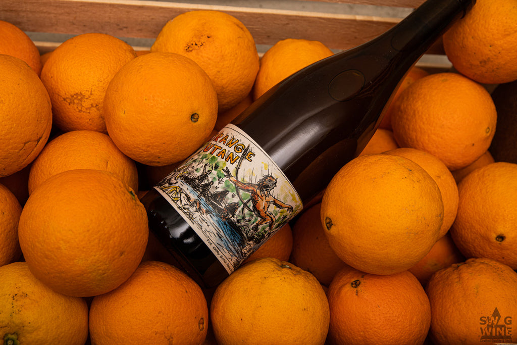 Naturwein und Orangewine Orange Utan vom Staffelter Hof an der Mosel - Flasche mit gezeichnetem Orang Utan in einer Kiste Orangen