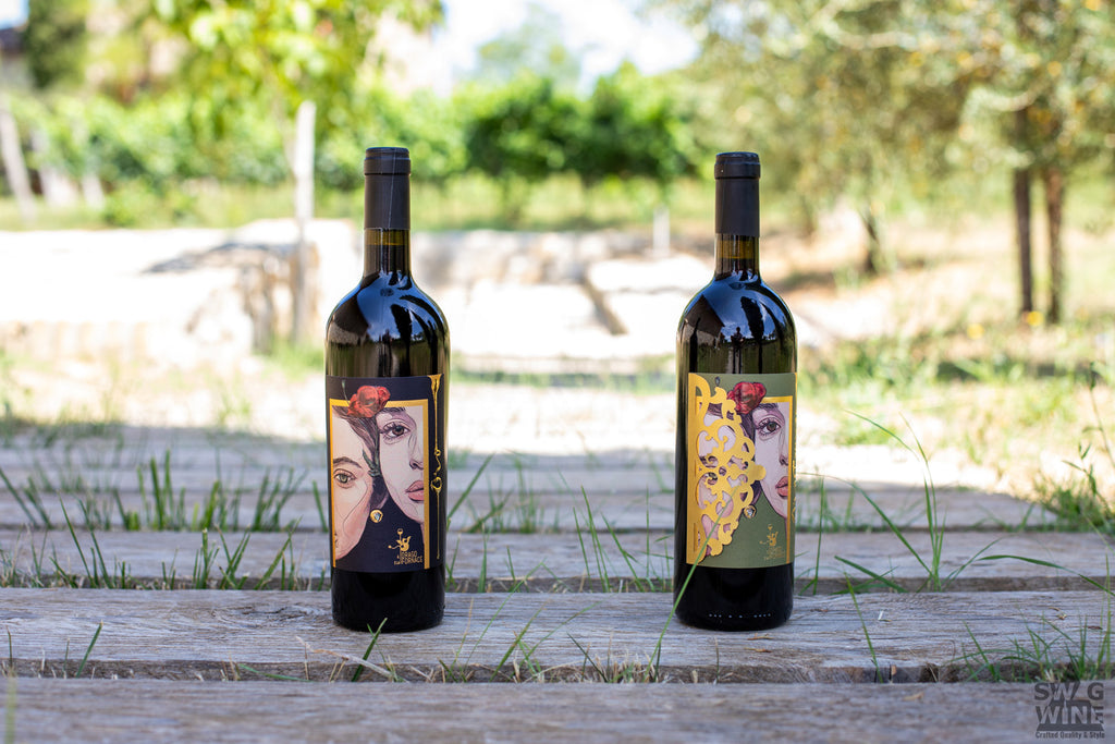 Oro Etrusco und Rosso von Il Drago e la Fornace - zwei Flaschen Rotwein aus der Toskana auf Holzdielen im Freien.