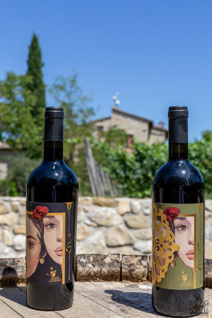 Oro Etrusco und Rosso von Il Drago e la Fornace - zwei Flaschen Rotwein aus der Toskana vor einer Steinmauer