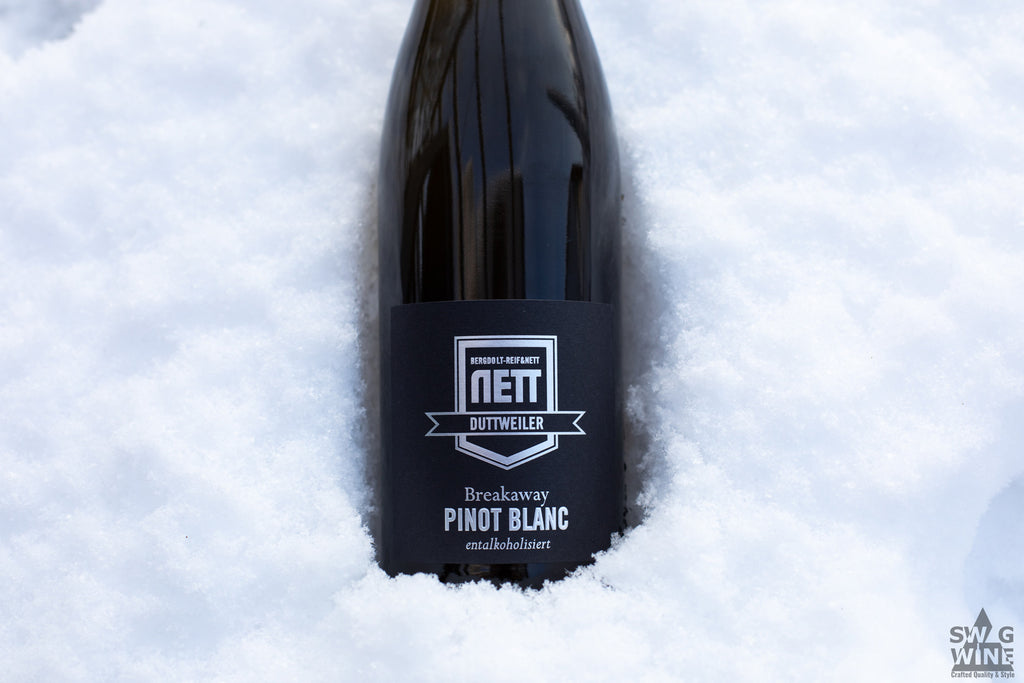 Alkoholfreier Weißwein Breakaway Pinot Blanc von Bergdolt-Reif und Nett aus der Pfalz - Nahaufnahme von Flasche im Schnee 
