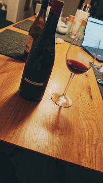 Spätburgunder Director's Cut von Kuhn Weine aus Freiburg - Weinflasche gedreht und eingeschenktes Glas