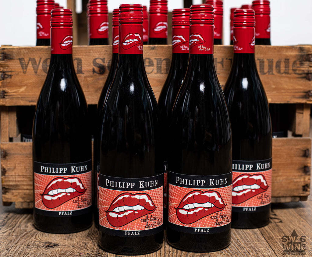 Red lips don't lie Rotwein Cuvée von Philipp Kuhn - Pfalz - mehrere Flaschen vor einer Weinkiste aus Holz