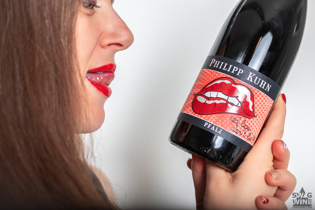 Flasche Red lips don't lie - Rotwein nach dem Vorbild von Bordeaux von Philipp Kuhn - Pfalz in der Hand einer Frau mit rotem Lippenstift