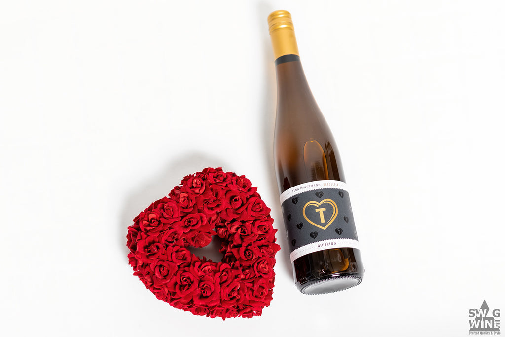 Riesling Herzglück von Tina Pfaffmann in der Pfalz - Weinflasche mit goldenem Herz neben Herz aus Rosen für Muttertag und als Geschenk für Liebe