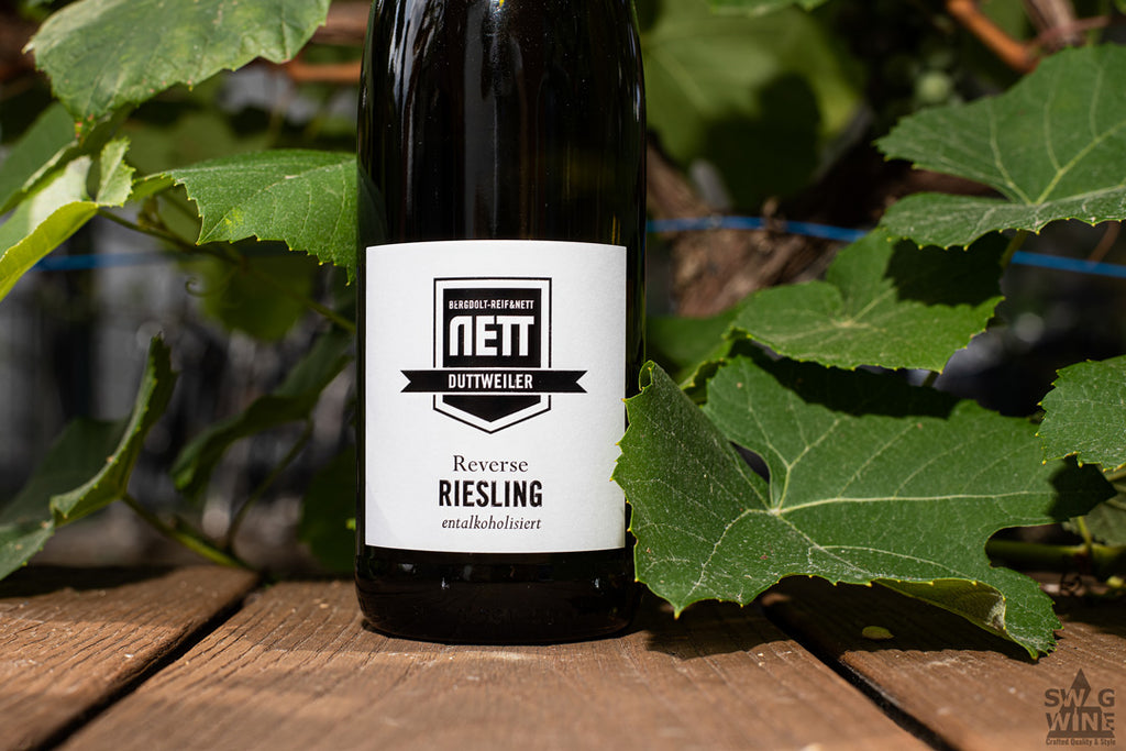 Riesling Reverse - alkoholfreier Weißwein von Bergdolt-Reif und Nett aus der Pfalz - Flasche vor Weinreben