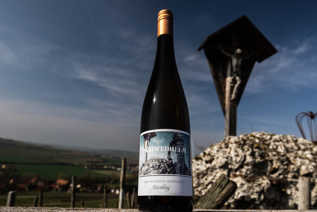 Riesling Schwarzer Herrgott von Weingut Schwedhelm - Zellertal - Flasche vor dem Schwarzen Herrgott