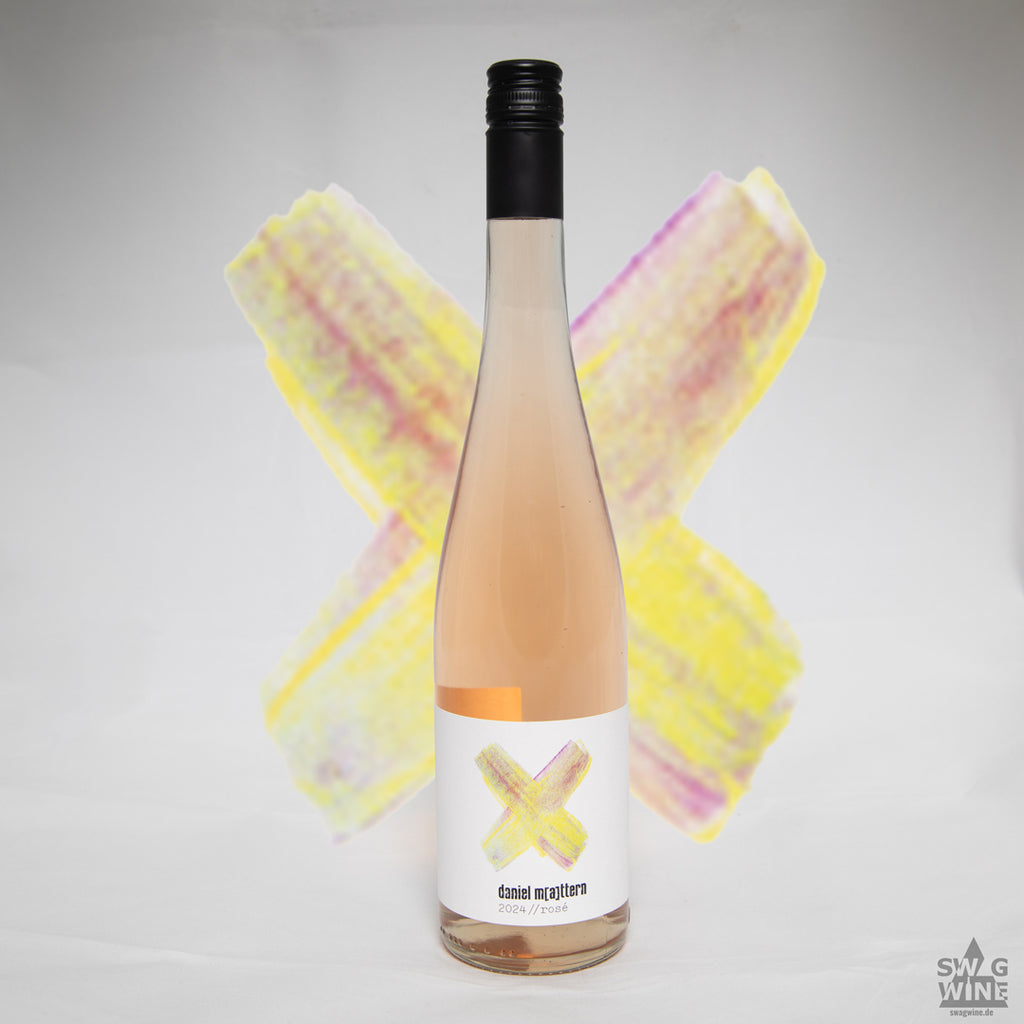 Rosé von Daniel Mattern aus Rheinhessen - Flasche vor gemaltem gelb-rosa Kreuz