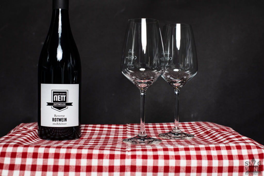 Nett Bergdolt-Reiff Reverse Rotwein entalkoholisiert auf Karodecke mit Weingläsern
