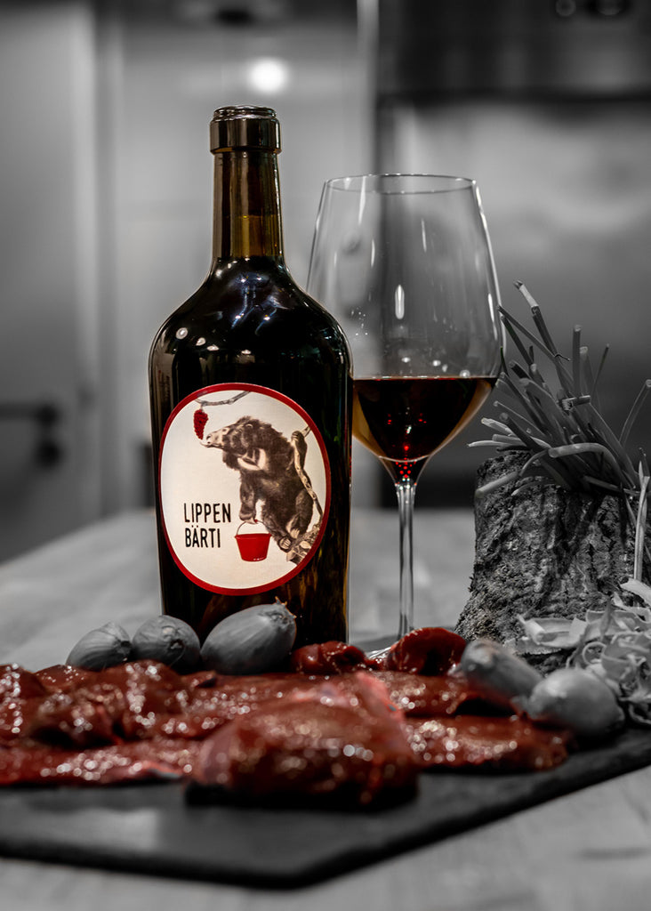 Spätburgunder Lippen Bärti von Wohlfahrt-Franke aus dem Rheingau - Weinflasche mit gefülltem Glas neben Essen