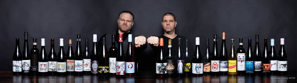 Sven und Markus die Inhaber von Swagwine vor dunklem Hintergrund mit einer Auswahl an coolen Flaschen aus dem Sortiment von Swagwine