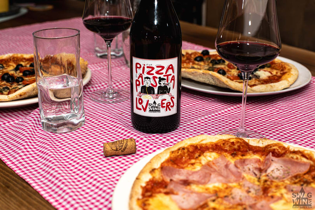 Swagwine Pizza and Pasta Lovers Rotwein - Flasche auf gedecktem Tisch mit eingeschenktem Glas