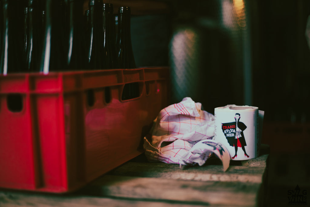 Etikettenrolle des Transsylvaner Sylvaner von Andreas Durst neben einer Kiste Weinflaschen