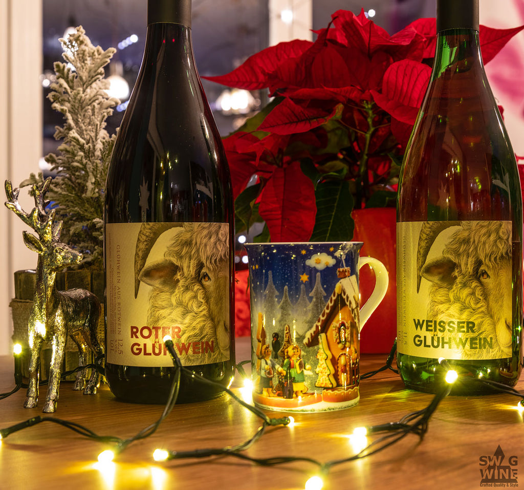 Winzerglühwein rot und weiß vom Weingut Hörner aus der Pfalz - Flaschen mit Tasse vor Weihnachtsstern und Deko im warmen Licht