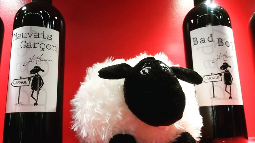 Bad Boy Bordeaux - Garagenwein von Chateau Valandraud. Zwei Flaschen mit dem schwarzen Schaf auf dem Etikett und einem Stoffschaf dazwischen.