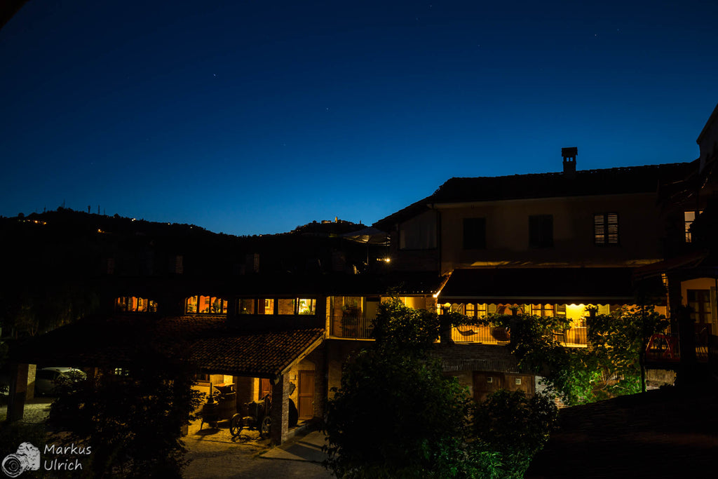 Weingut Cascina del Monastero bei Nacht mit Beleuchtung und Himmel in blauer Stunde
