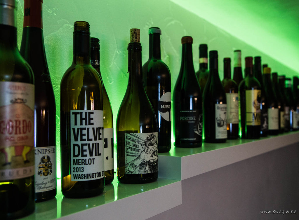 Swagwine Weinabo Bild von leeren Weinflaschen auf einem bunt beleuchteten Regal