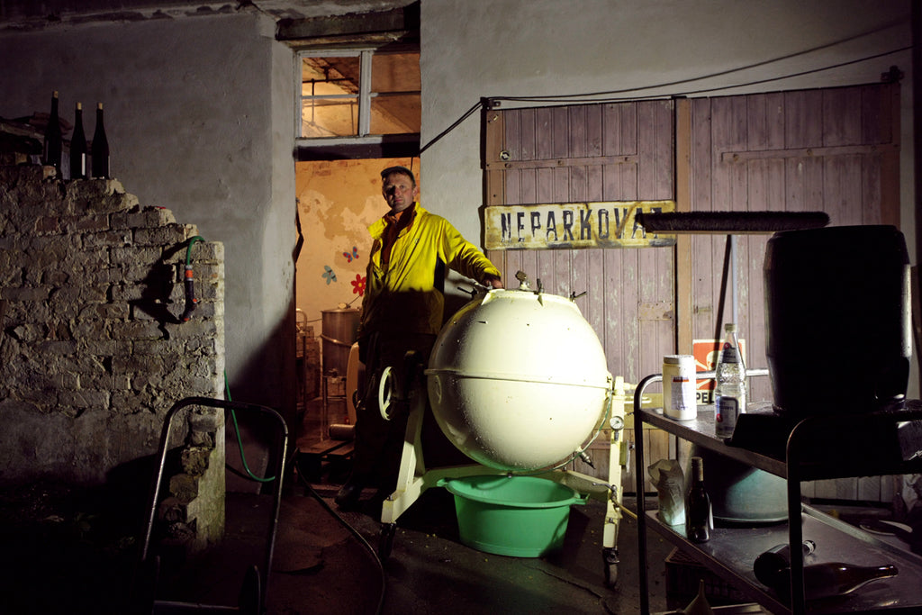 Winzer Andreas Durst vor seiner Garage beim Säubern eines Weintanks in der Pfalz