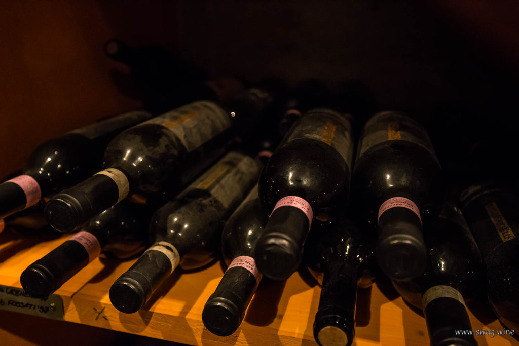 Barolo DOCG Fossati Weinflaschen liegen im Weinkeller im Regal bei Enzo Boglietti, La Morra - Piemont