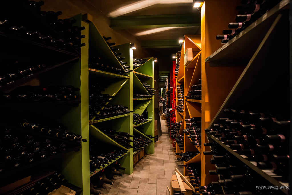 Weinkeller mit vielen Flaschen in bunten Regalen bei Enzo Boglietti . Hier lagern ältere Jahrgänge.