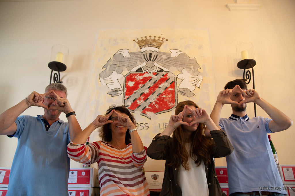 Familie Haag vom Weingut Schloss Lieser zeiget das Swagwine Zeichen - das Auge trinkt mit