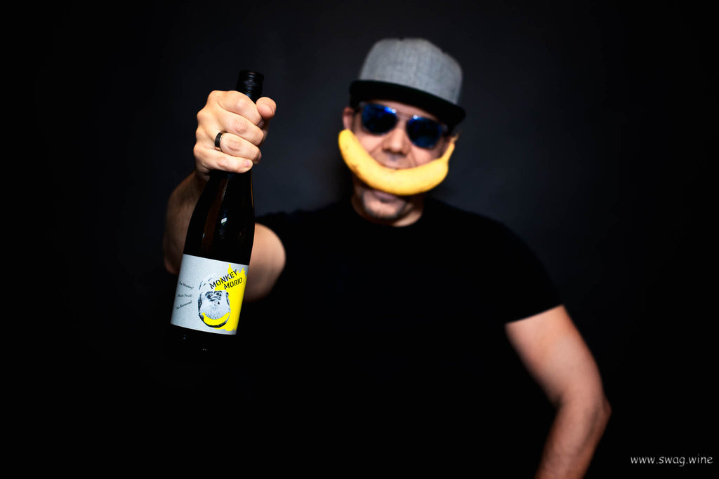 Monkey Morio Muskat - Weißwein von Hanewald-Schwerdt aus der Pfalz - Markus von Swagwine mit Flasche in der Hand und Banane vor dem Mund