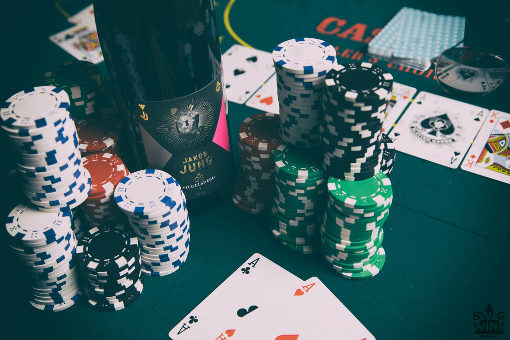 Riesling Großes Gewächs Siegelsberg von Weingut Jakob Jung aus dem Rheingau - Flasche als Einsatz beim Poker neben Pokerchips und Full House