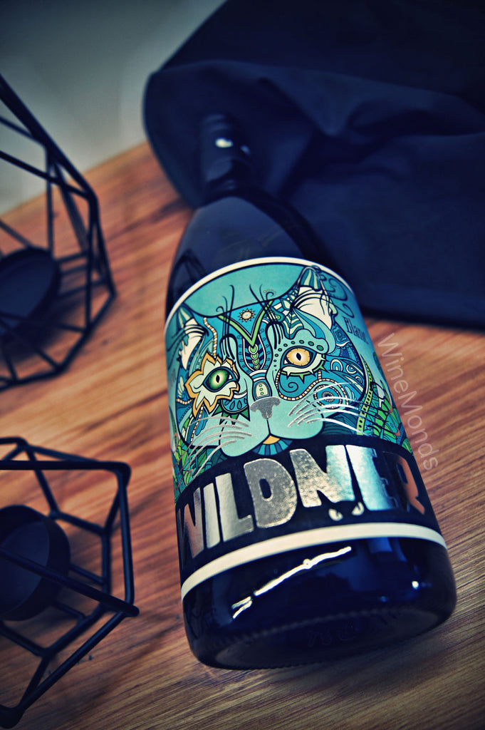 Sauvignon Blanc von Weingut Wildner aus Rheinhessen - Flasche mit ägyptischer Katze in hellblau auf Holztisch neben Deko