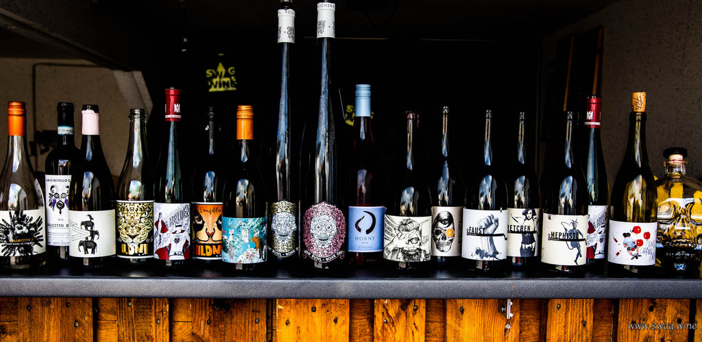 Weinflaschen von Swagwine mit ausgefallenen Etiketten mit Style stehen nebeneinander auf einer Bar