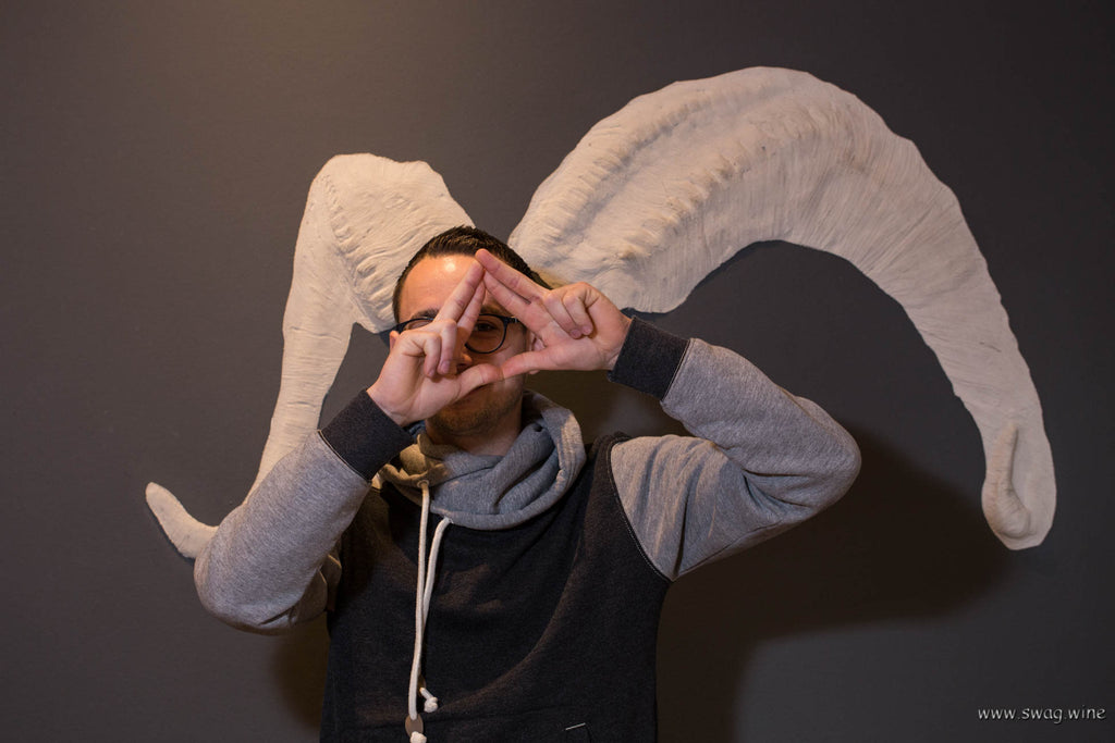 Winzer Thomas Hörner zeigt das Swagwine Zeichen - das Auge trinkt mit - vor dem Widderhorn